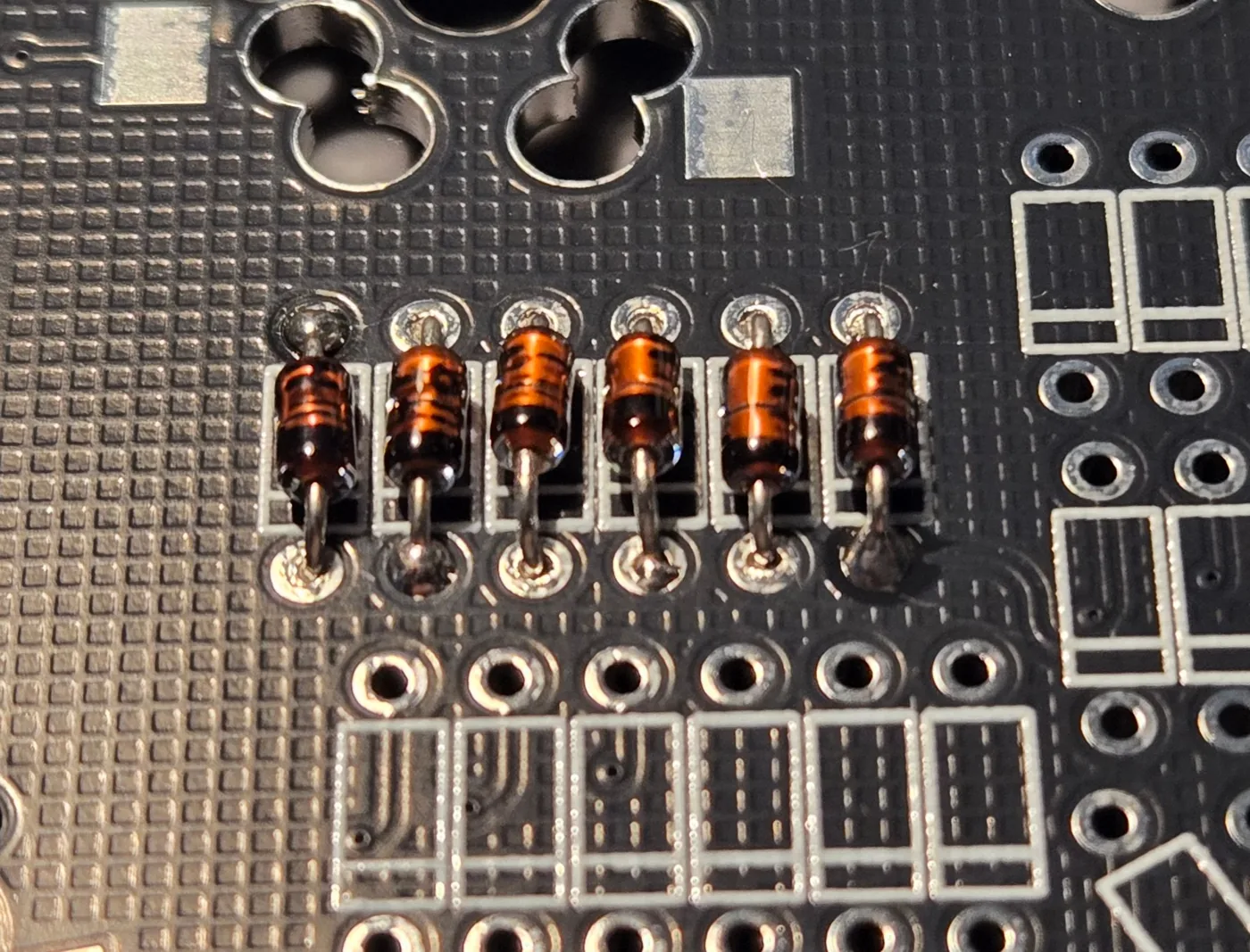 基板の枠に差し込んだ、6本のダイオード。黒い帯が全部同じ側にそろっている