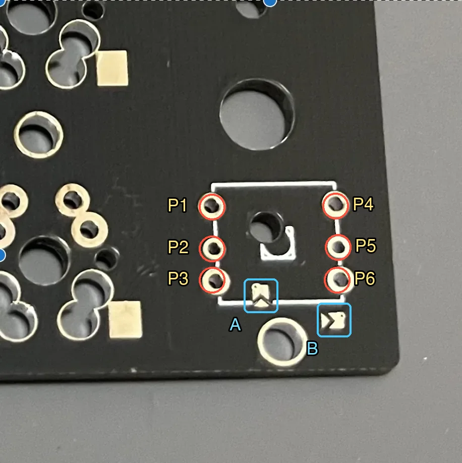 5方向スイッチ用の6つの穴(P1からP6)と、その下の矢印形の小さなランド2つ(AとB)に印を付けた写真
