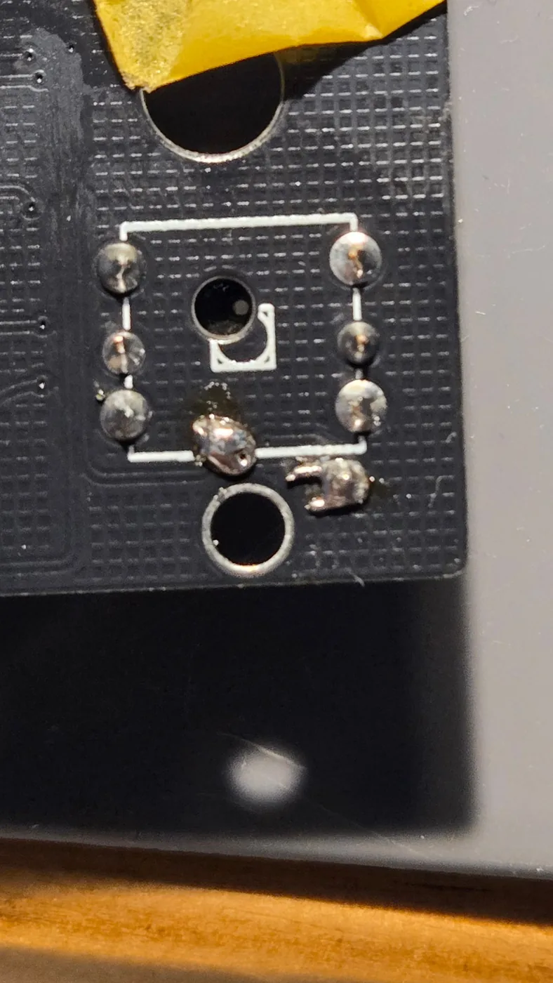 左の基板。枠の下の2つのランドに、はんだの塊が付いている