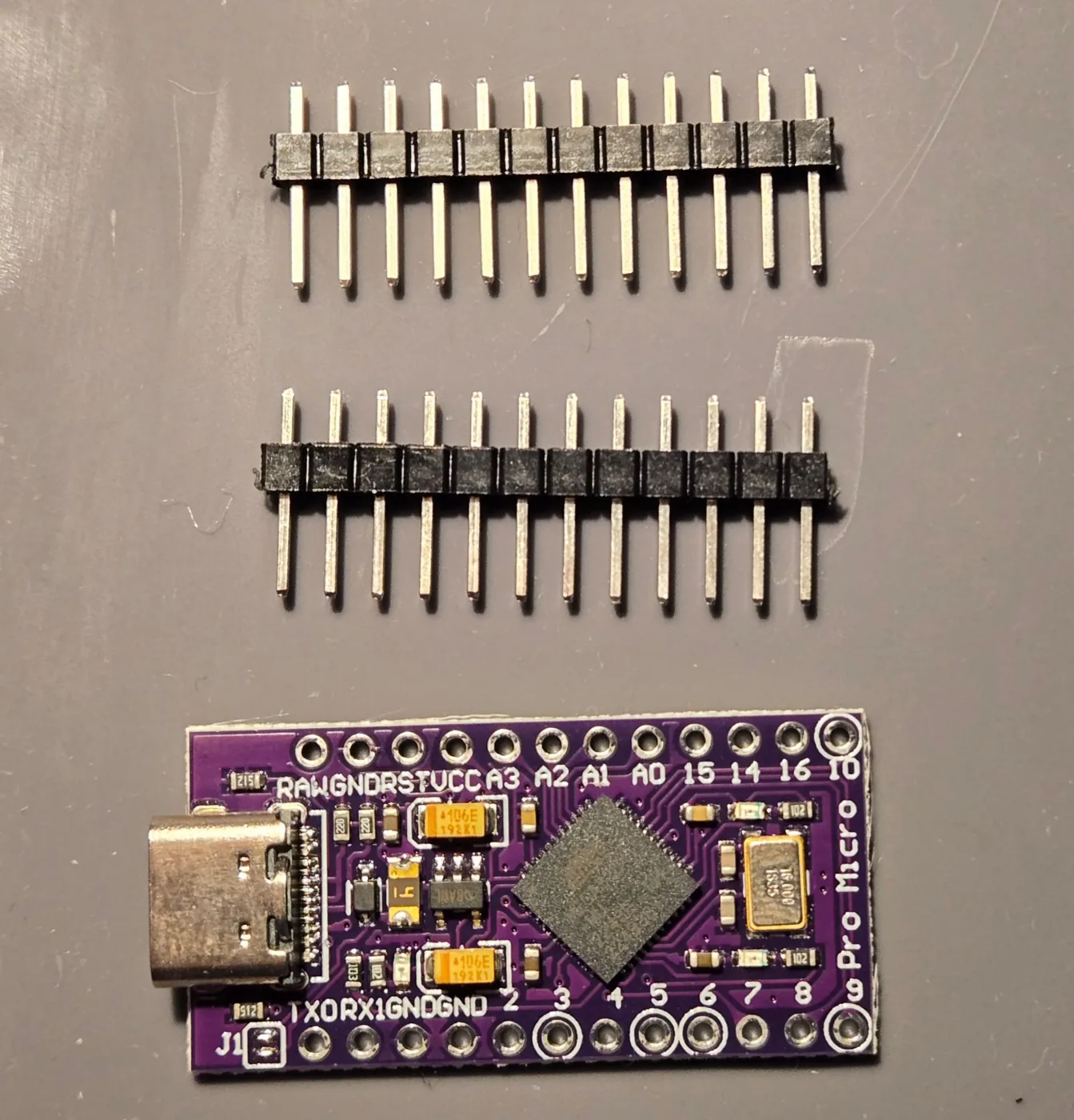 ピンヘッダ2本と、紫色の Pro Micro 互換ボード